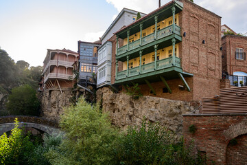 Obraz premium Ornate balconies adorn buildings clinging to cliffs in Leghvtakhevi Canyon in Tbilisi, Georgia. This reflects a blend of cultures, showcasing Tbilisi's diverse heritage as a crossroads of empires.