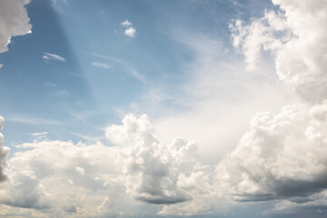 Wolkengebilde mit Sonnenstrahlen vor blauem Himmel