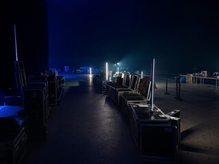 Professional backstage area with equipment flight cases and gear storage in dark venue setting