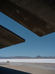 View of salt flats desert landscape framed by concrete architectural structure creating geometric...