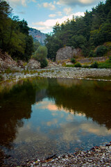 Mountain landscape. Gorge with river and nature leflections in the water. Blue sky. Greece. Peaceful nature.