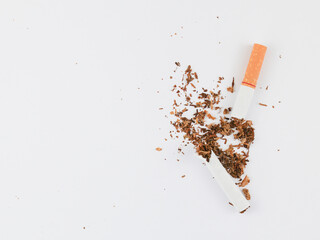 Flat lay of Broken cigarettes and tobaccos all around the cigarettes separated on white Background....