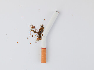 Top view Broken cigarettes and tobaccos all around the cigarettes separated on white Background....