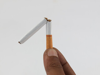Male hand holding broken cigarette, refusing cigarette and lung healthy concept. Isolated white...