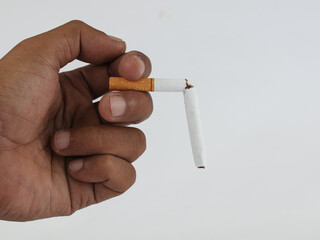 Male hand holding broken cigarette, refusing cigarette and lung healthy concept. Isolated white background 