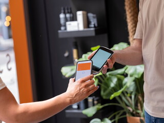 Close-up of contactless payment transaction between smartphone and payment card in contemporary environment