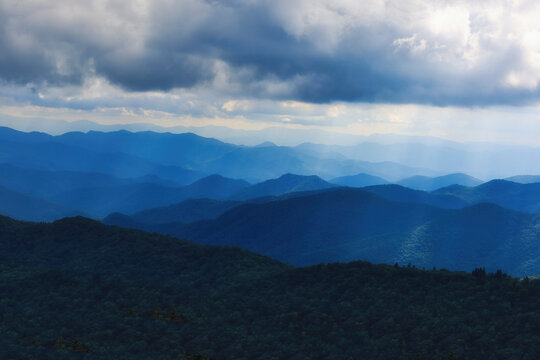 A dark cloudy landscape of the iconic Blue Ridge Mountains in their splendor in North Carolina in deep blue colors.