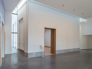Bright modern interior entrance hall with natural lighting, concrete flooring and minimal architectural elements