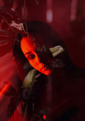 Double exposure image of woman and flowers with intense red ligh