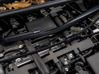 Close-up view of modern car engine compartment showing various mechanical components and automotive engineering