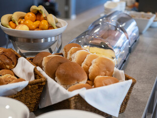 Continental breakfast buffet featuring fresh bread rolls and fruit selection in elegant hotel dining setup
