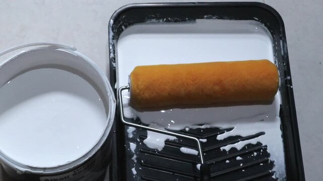 Man's hand preparing a paint roller. Painting a house