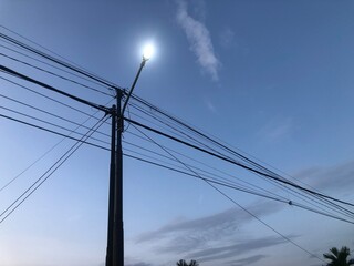 Electric utility pole with power lines against a clear sky. Essential infrastructure for...