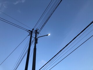 Electric utility pole with power lines against a clear sky. Essential infrastructure for...