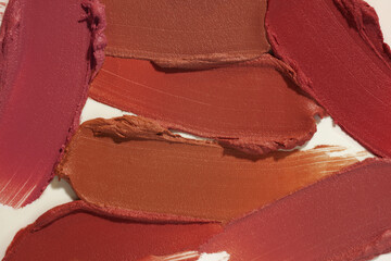 Lipstick burgundy purple pink red orange beige brown palette set smudge background texture on white grey background