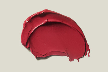 Lipstick dark red burgundy cherry smudge sample swatch isolated on beige neutral background...