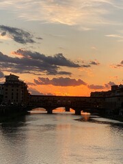 Naklejka premium Dramatic sunset behind Ponte Vecchio bridge in Florence, Italy