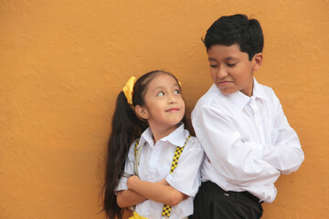 Latino older brother and younger sister play and tease each other during their free time on vacation