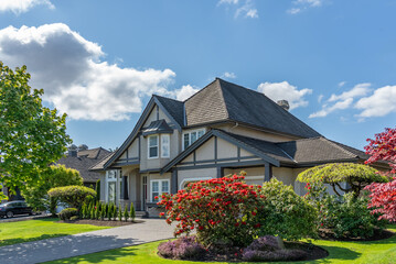 Two story stucco luxury house with nice spring blossom landscape in Vancouver, Canada, North...