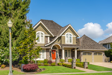 Two story stucco luxury house with nice spring blossom landscape in Vancouver, Canada, North America. Day time on May 2025.