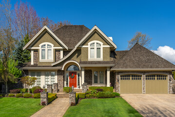 Obraz premium Two story stucco luxury house with nice spring blossom landscape in Vancouver, Canada, North America. Day time on May 2025.