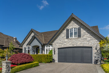 Two story stucco luxury house with nice spring blossom landscape in Vancouver, Canada, North America. Day time on May 2025.