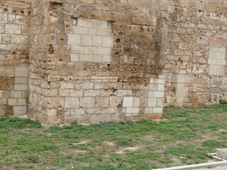 Weathered stone wall corner revealing multi-stone repairs and varied masonry techniques
