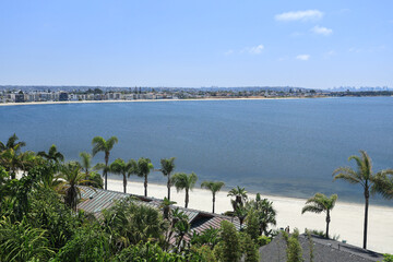 Beach and vacation rentals along curving shore of Sail Bay on a clear summer day, San Diego, CA; copy space