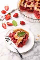 Piece of tasty strawberry pie and berries on white marble table, above view