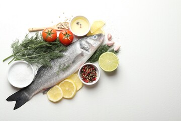 Fresh raw seabass fish with spices on white table, flat lay and space for text. Seafood delicacies