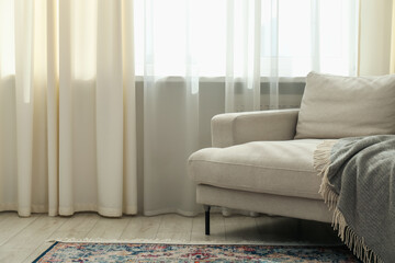 Stylish furniture near window with curtains in living room. Interior design