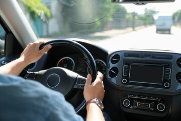 Man driving car with steering wheel, closeup