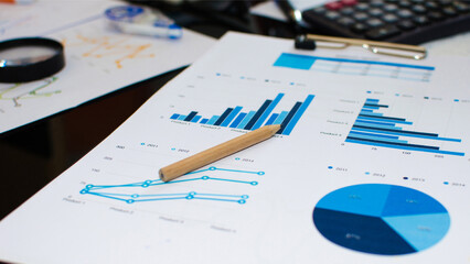 Business team analyzing financial data and marketing charts using graphs on office desk