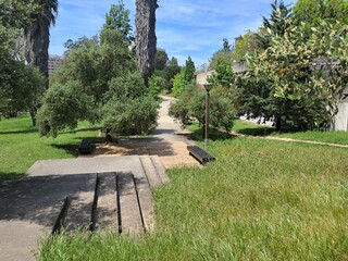 Concrete stairs leading to a park path with benches and streetlight