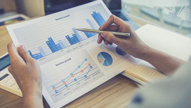 Business team analyzing financial data and marketing charts using graphs on office desk