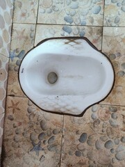 Top view of an old and used Asian-style squat toilet. Old squat toilet in a rustic bathroom