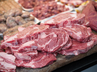 Raw beef steak on a white plate in a restaurant setting. Chef cutting fresh meat before cooking.