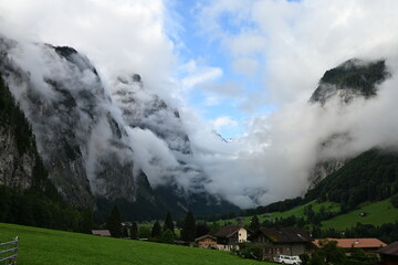 Scenic alpine valley with dramatic clouds and mountain village