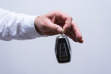 Elegant keychain remote control for a car in a male hand.