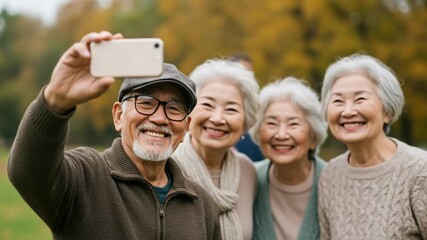 Happy senior friends taking a selfie outdoors in autumn