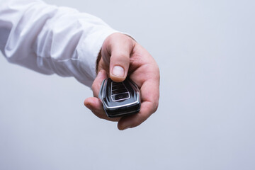 Elegant keychain remote control for a car in a male hand.