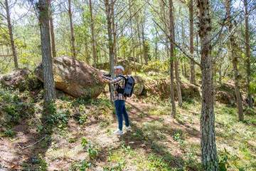 Wide-angle view of photographer taking a selfie in a pine forest