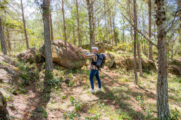 Fototapeta premium Smiling photographer taking a selfie in a sunny pine forest