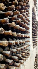 Aged Wine Bottles in Traditional Cellar.
Dusty old wine bottles aging in rows inside a historic...