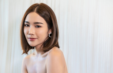 Closeup portrait of beauty asian woman with fair perfect healthy glow skin hand touch shoulder copy space, young beautiful asia girl with pretty smile on face. Beauty korean clinic skincare banner