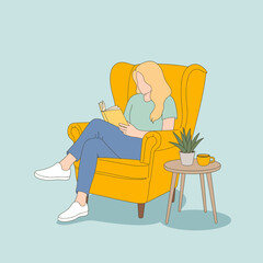 A relaxed young woman is seen reading a book while seated on a yellow armchair, connecting with her peaceful surroundings and a warm cup of tea on a small table.