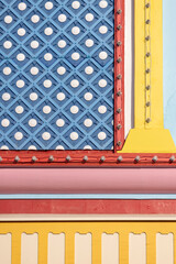 Colorful retro amusement park background showing geometric patterns and lights with nostalgic colors of bold and pastel reds, blue, yellow, pink and aqua