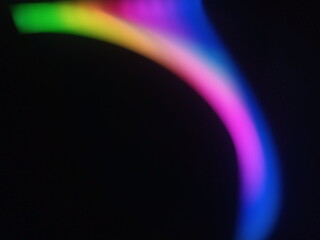 A multicolored abstract by moving strokes of light, creating bright, swirling streaks of rainbow-colored light on a dark background