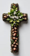 Rustic wooden cross adorned with acorns, moss, and delicate white flowers, creating a nature-inspired religious artifact