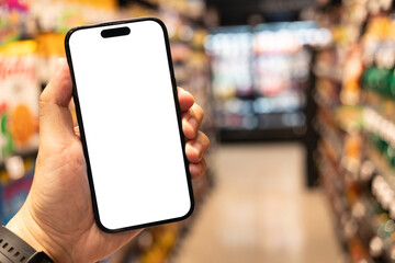 Hand Holding Smartphone with Blank Screen in Supermarket. a blank white screen. The background is a blurred supermarket aisle. shopping, mobile commerce, online shopping concepts.